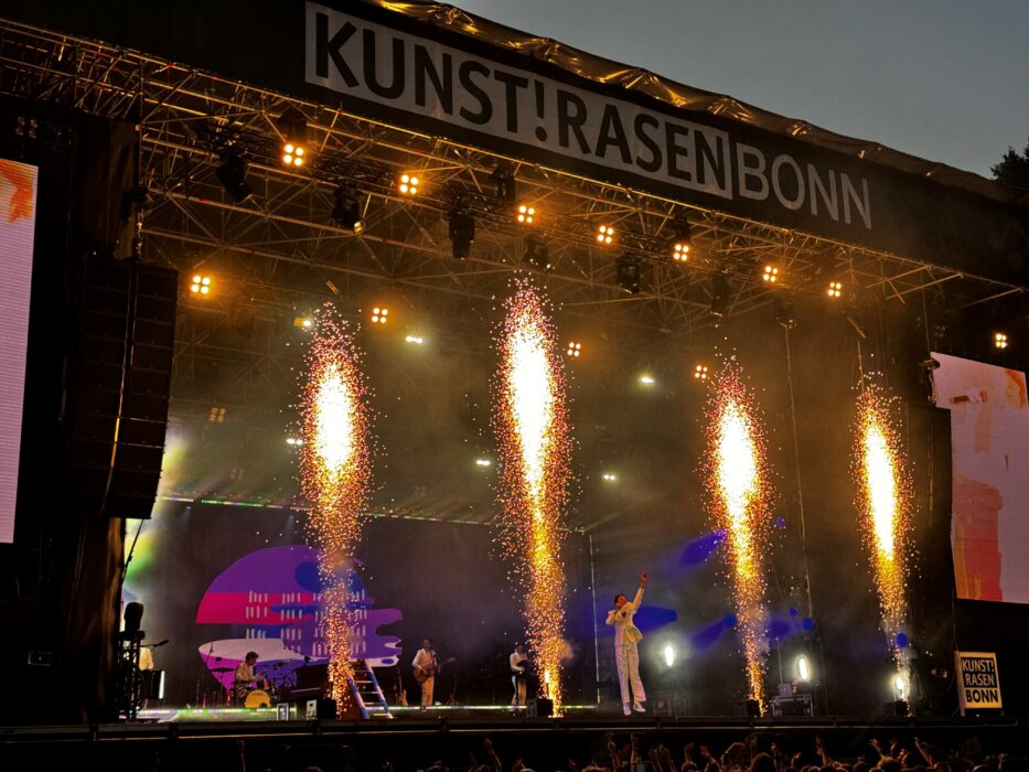 mika auf dem kunstrasen in bonn während pyroeffekten